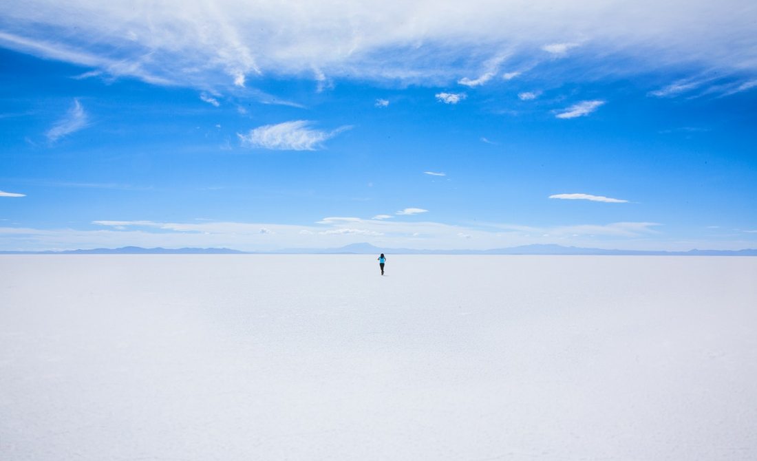 Woman walking on sand with blue sky